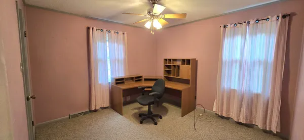 a view of a workspace with furniture and a window