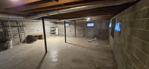 a view of water heater room with wooden floor