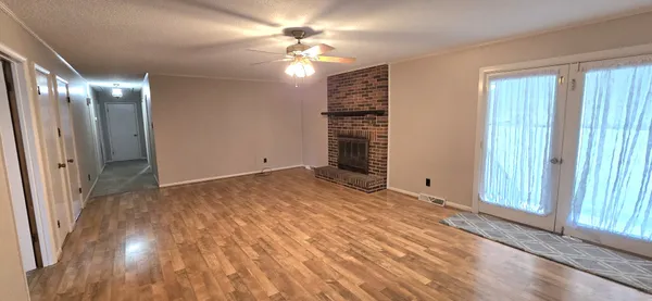 a view of empty room with window and ceiling fan
