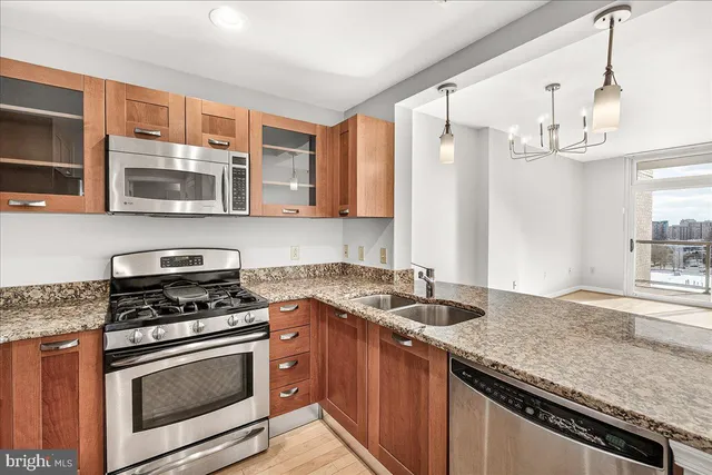 a kitchen with stainless steel appliances granite countertop a sink stove and microwave