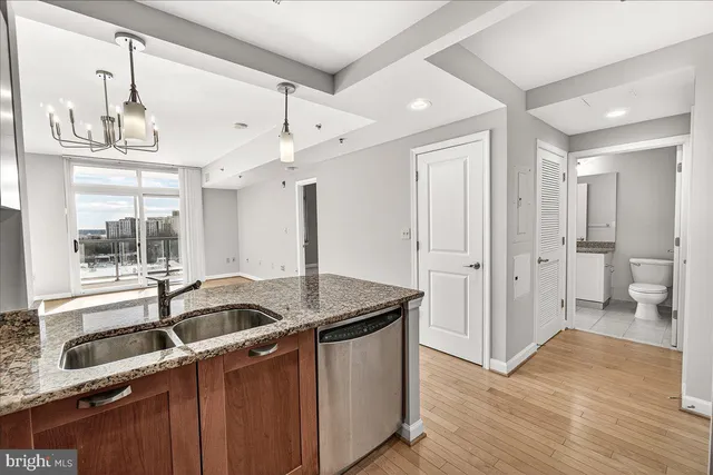 a kitchen with stainless steel appliances granite countertop a sink and a refrigerator