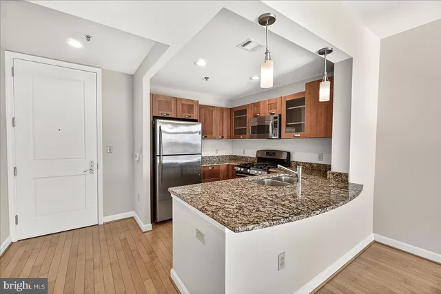 a kitchen with stainless steel appliances granite countertop a sink refrigerator and cabinets