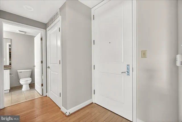 a view of a bathroom with white walls and glass door