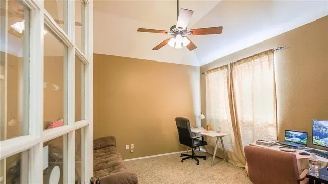 a view of a workspace with furniture and a window
