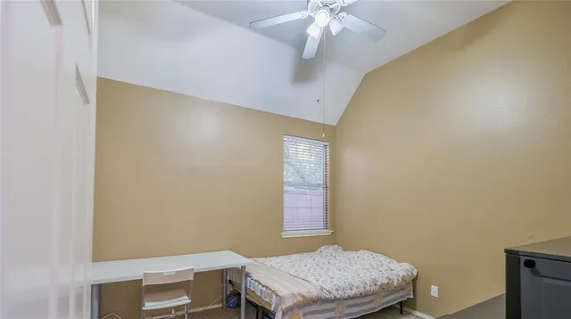 a room with a bed and a chandelier fan