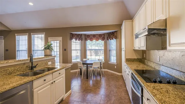 a kitchen with stainless steel appliances granite countertop a stove a sink and a granite counter tops with white countertops
