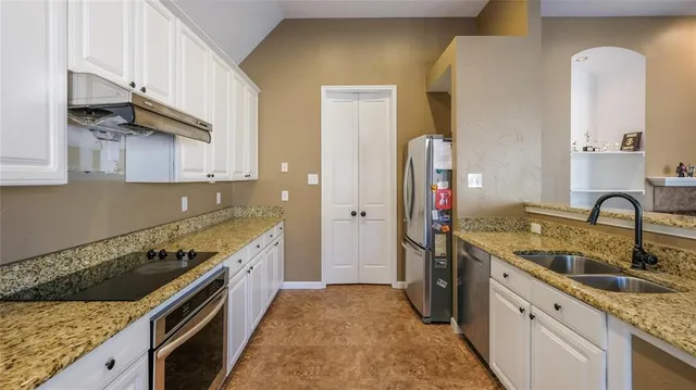 a kitchen with stainless steel appliances granite countertop a sink stove and cabinets
