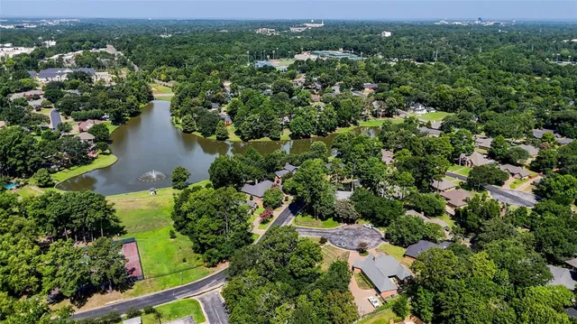 an aerial view of residential house with outdoor space and trees all around