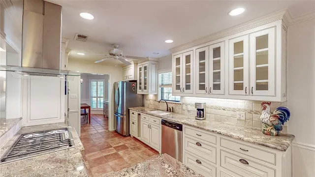 a kitchen with granite countertop a sink stainless steel appliances and cabinets