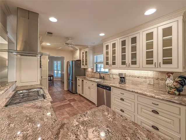 a large kitchen with granite countertop a sink and cabinets