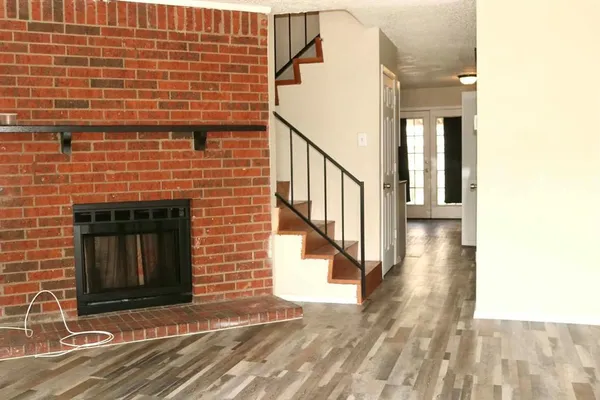 a view of a brick house with wooden floor and fence
