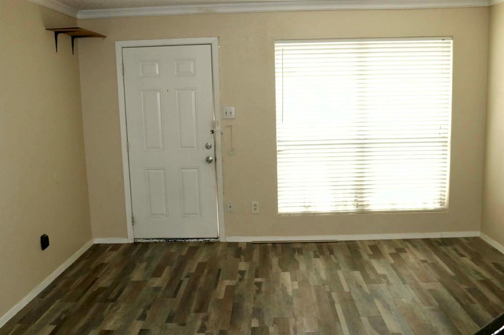 10500 Lake June Road, Unit M07 Dallas, TX 75217 - Photo 2 of 14 a view of an empty room with wooden floor and a window