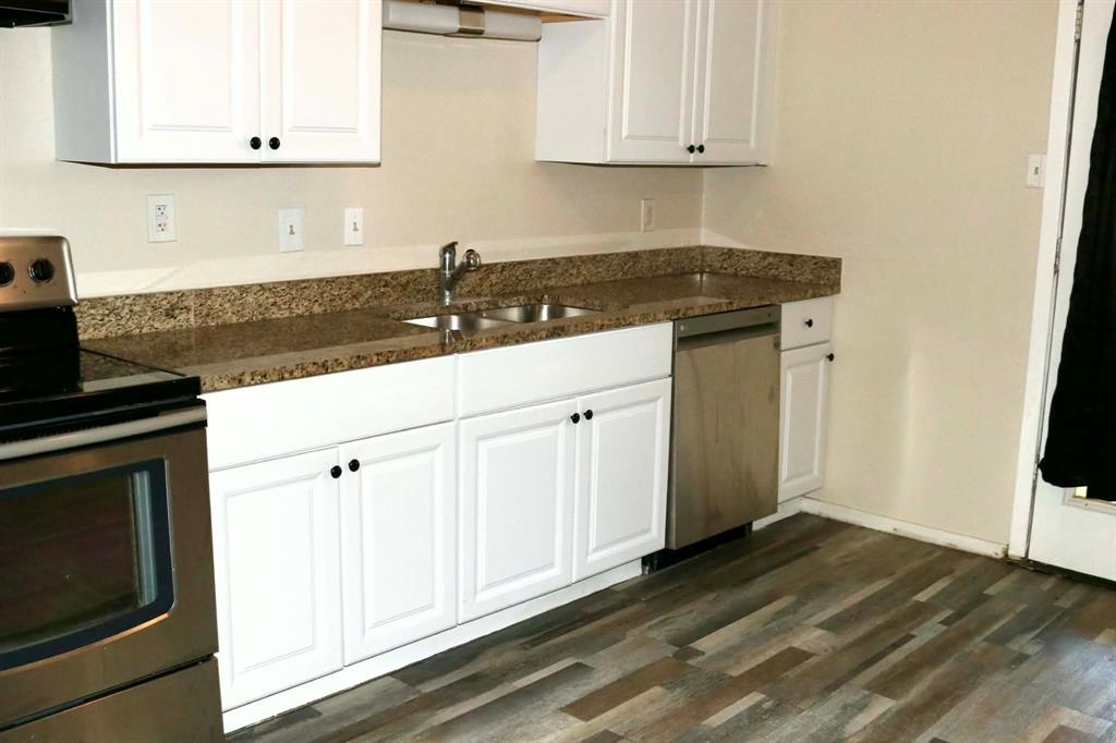 10500 Lake June Road, Unit M07 Dallas, TX 75217 - Photo 7 of 14 a kitchen with granite countertop white cabinets and black appliances