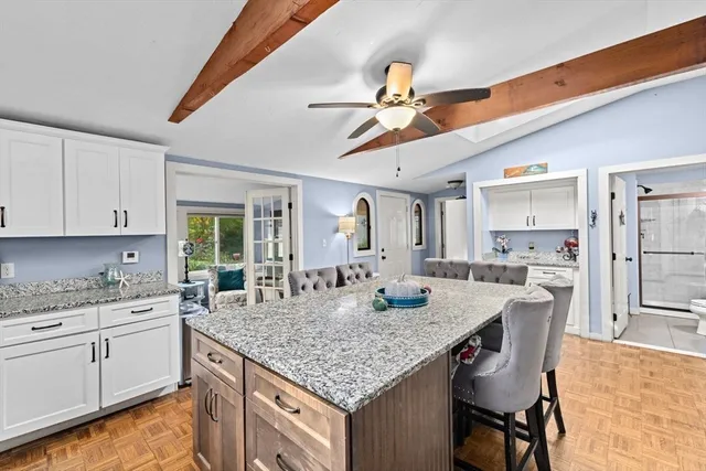 a kitchen with granite countertop kitchen island a counter space dining table and stainless steel appliances