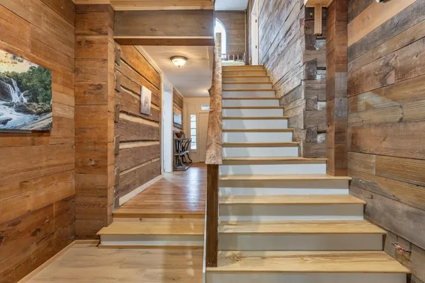 a bedroom with a bed a dresser and wooden floor