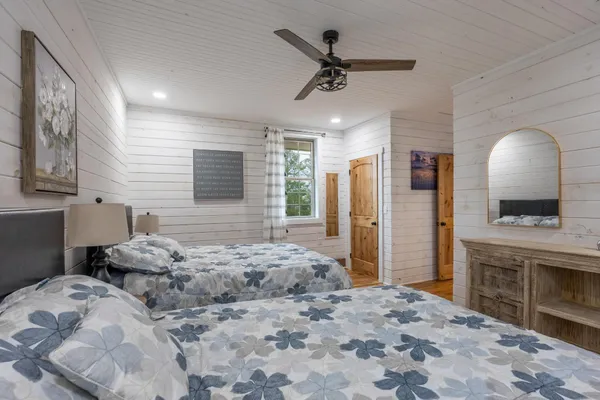 a bedroom with a bed a couch and a flat screen tv