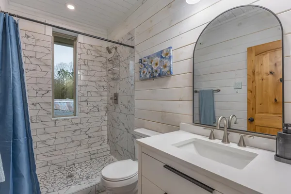 a bedroom with a bed and glass walk in closet