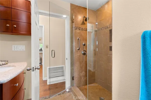 a bathroom with a granite countertop shower sink and mirror