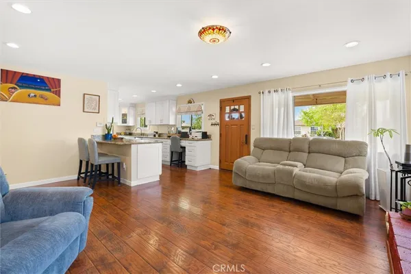 a living room with furniture and a dining table with kitchen view
