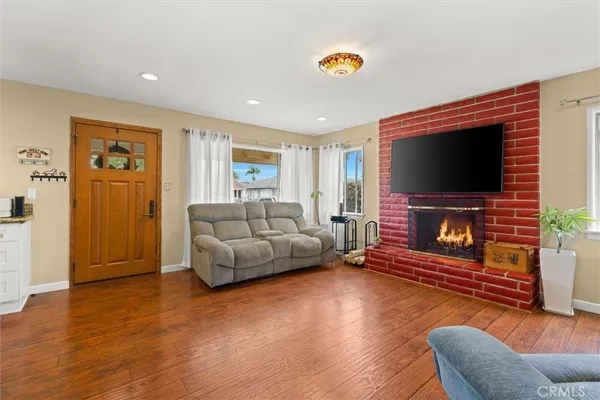 a living room with furniture a flat screen tv and a fireplace
