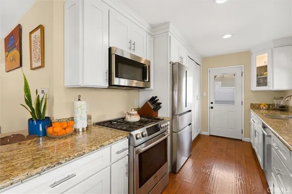 a kitchen with stainless steel appliances granite countertop a stove a sink and a refrigerator