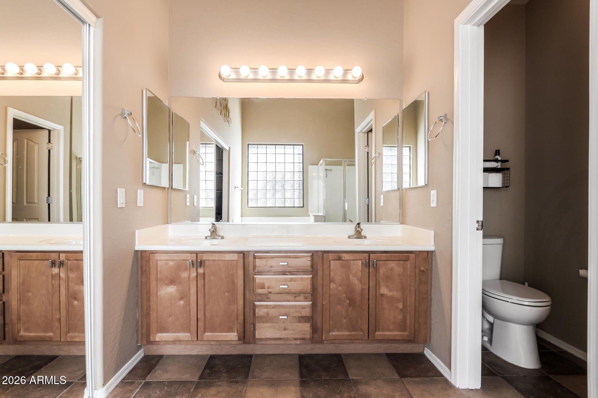 2115 West Branham Lane Phoenix, AZ 85041 - Photo 19 of 35 a bathroom with a granite countertop sink a toilet and a large mirror