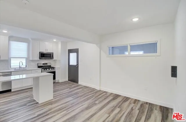 a kitchen with a refrigerator and a stove top oven