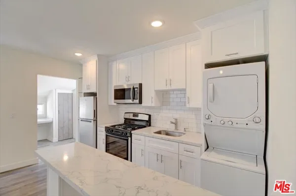 a kitchen with stainless steel appliances a refrigerator sink and cabinets
