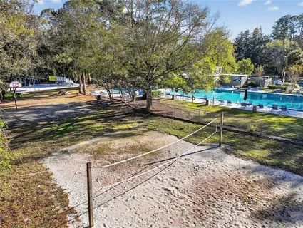 a view of a tennis ground with large trees