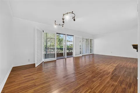a view of a kitchen with wooden floor and a refrigerator