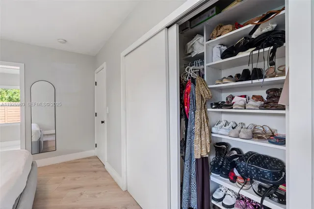 a view of walk in closet with clothes and shoes