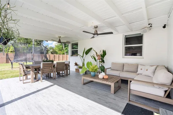 a living room with patio furniture and a potted plant
