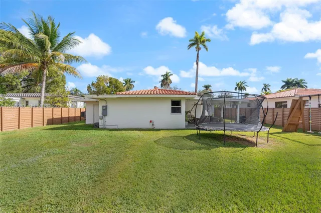 a view of a house with pool and a yard