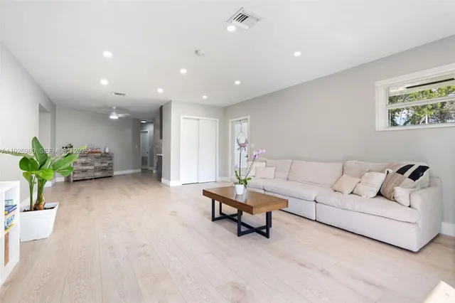 a living room with furniture and a potted plant