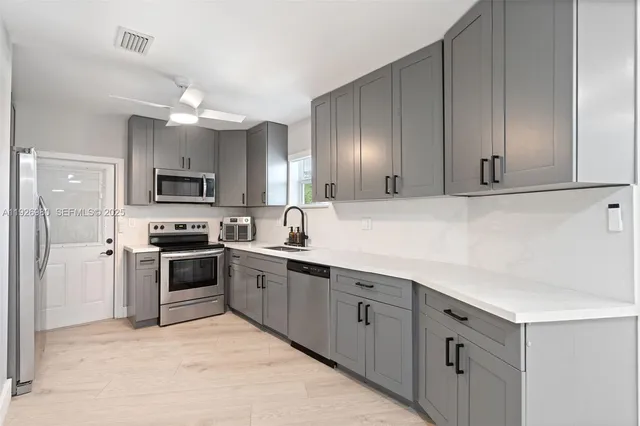 a kitchen with cabinets a sink and stainless steel appliances