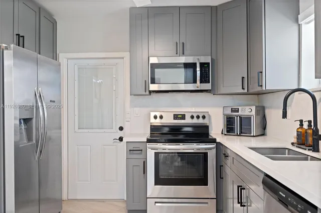 a kitchen with cabinets stainless steel appliances and a sink