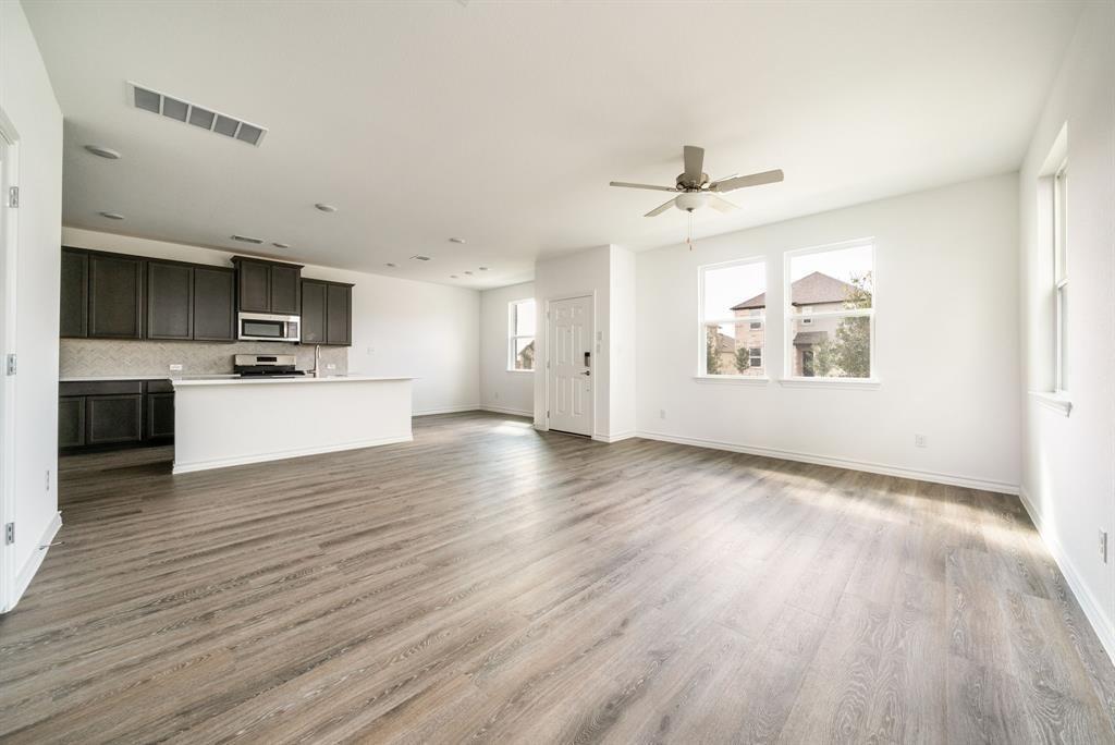 Unfurnished living room featuring light wood-style flooring and ceiling fan