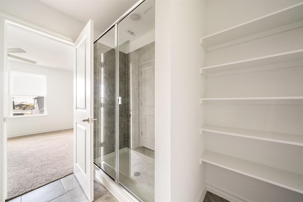 123 Watkinville Road Hutto, TX 78634 - Photo 11 of 30 Full bath featuring carpet floors, a stall shower, tile patterned flooring, and a closet