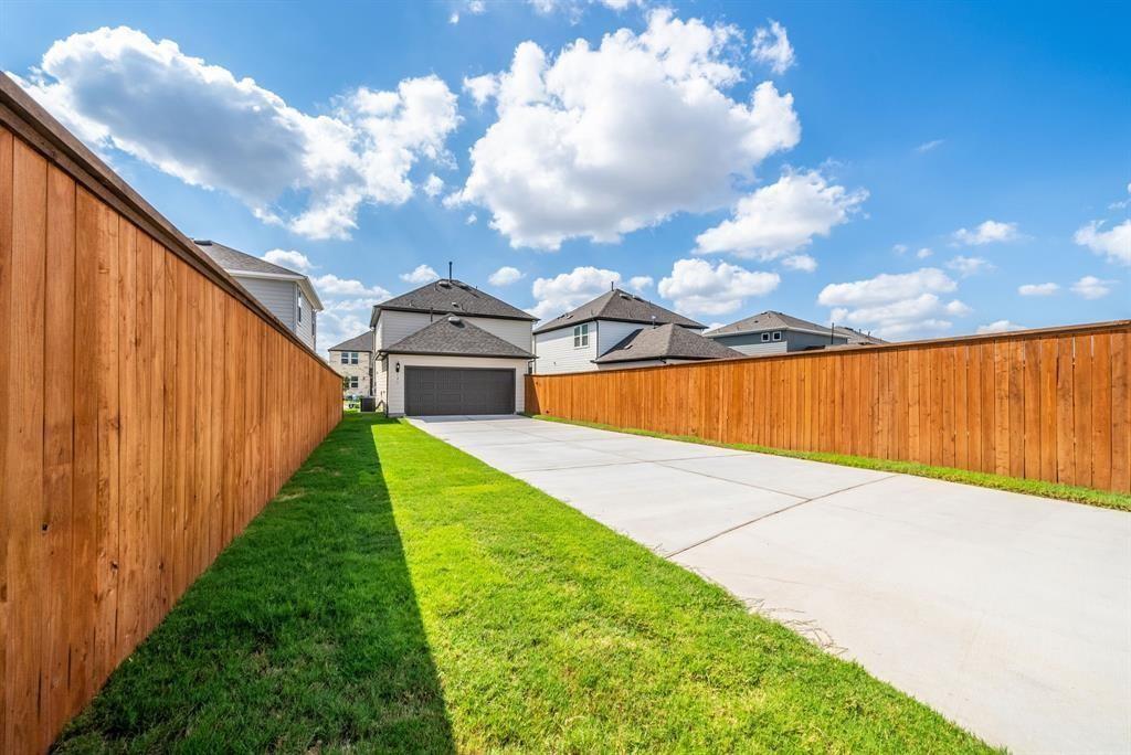123 Watkinville Road Hutto, TX 78634 - Photo 27 of 30 View of yard featuring a garage and concrete driveway