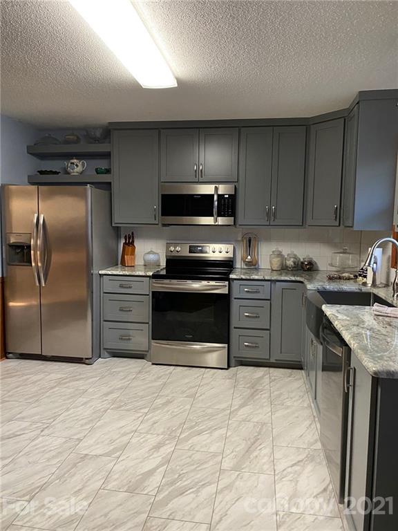 4903 Horseshoe Bend Road Hudson, NC 28638 - Photo 11 of 26 a kitchen with stainless steel appliances granite countertop a stove a sink and a refrigerator