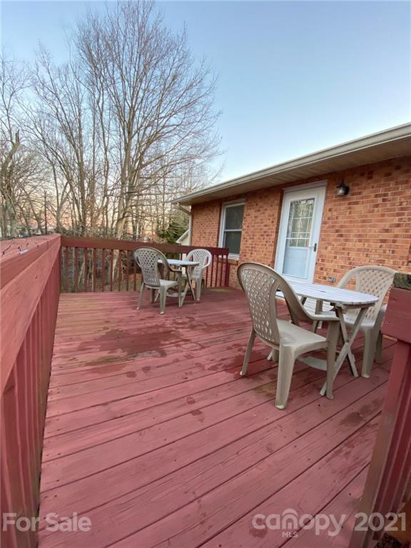 4903 Horseshoe Bend Road Hudson, NC 28638 - Photo 4 of 26 a view of a patio with table and chairs with wooden floor and fence