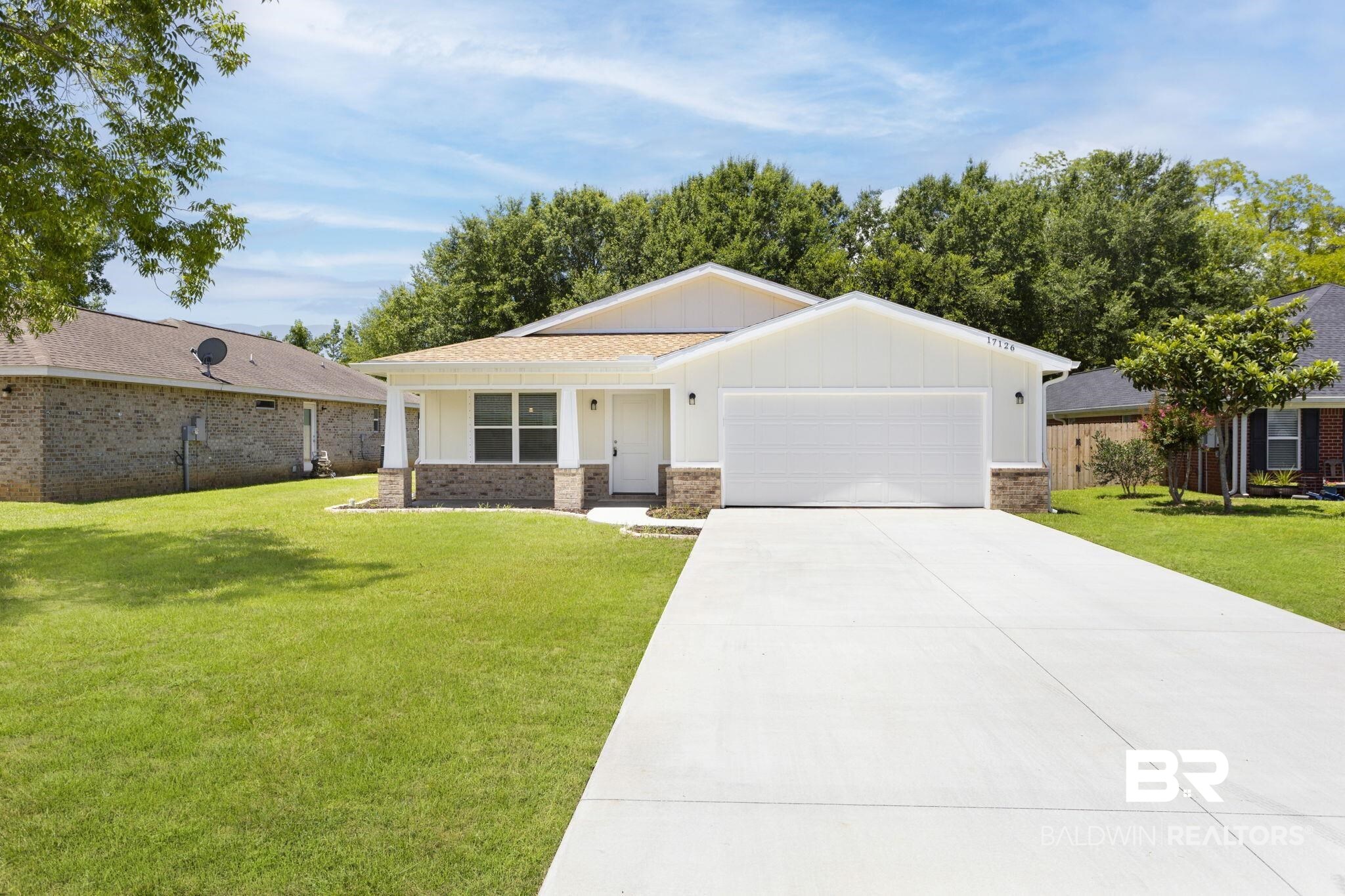 17126 Sugar Loop Foley, AL 36535 - Photo 26 of 28 View of front of house featuring board and batten siding, an attached garage, driveway, and a front lawn