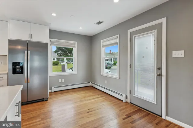a view of kitchen with a fridge and wooden floor