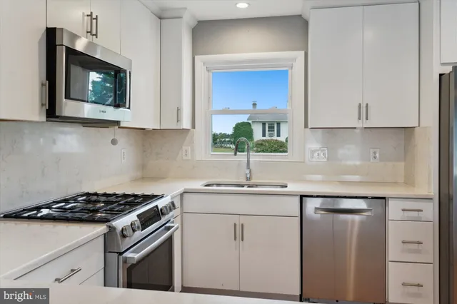 a kitchen with appliances a sink and cabinets