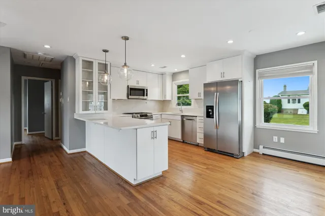 a kitchen with stainless steel appliances a refrigerator and a stove top oven