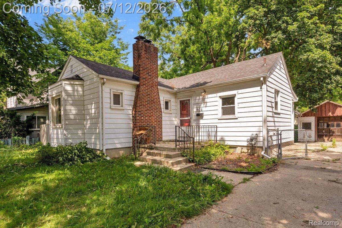 624 North Prospect Road Ypsilanti, MI 48198 - Photo 2 of 28 White siding residence featuring a red brick chimney and black asphalt shingle roof