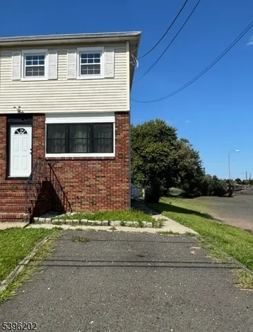 a view of house with backyard and trees in the background