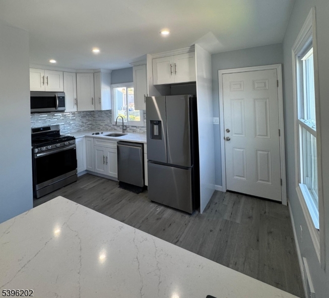 37 Irving Street Carteret, NJ 07008 - Photo 2 of 10 a kitchen with stainless steel appliances granite countertop a refrigerator and a stove top oven