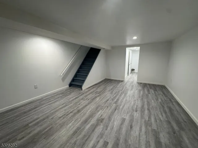 an empty room with wooden floor and stairs