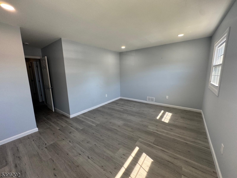 37 Irving Street Carteret, NJ 07008 - Photo 5 of 10 wooden floor in an empty room with a window